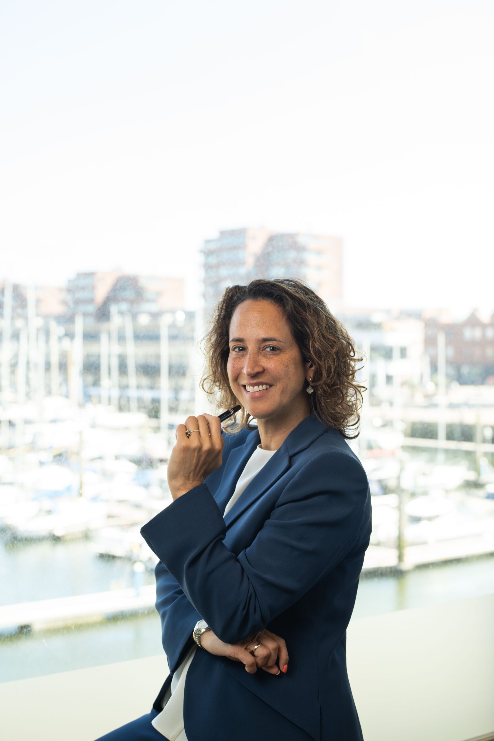 Vrouw met pen in haar hand voor een haven