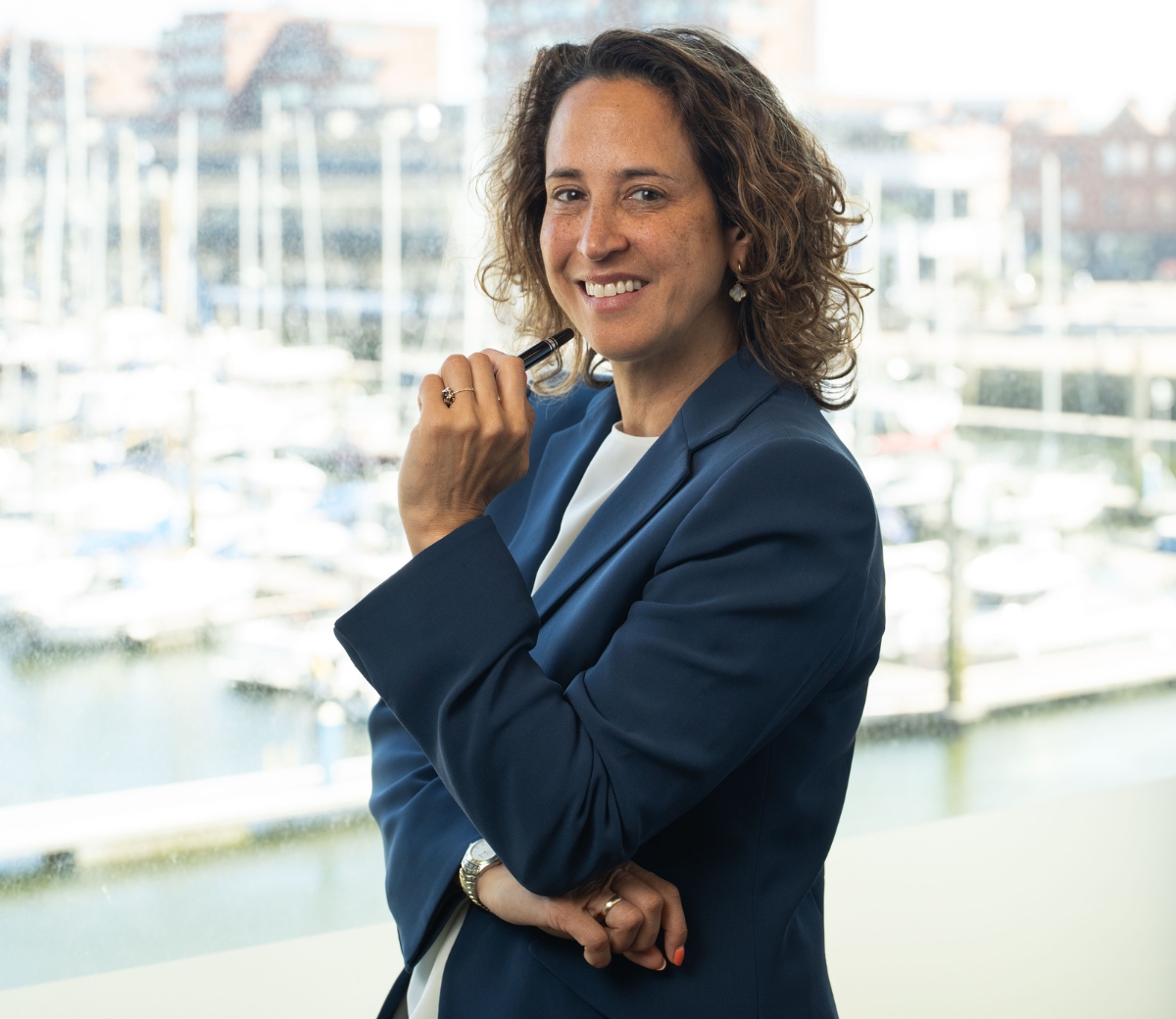 Vrouw met pen in haar hand voor een haven